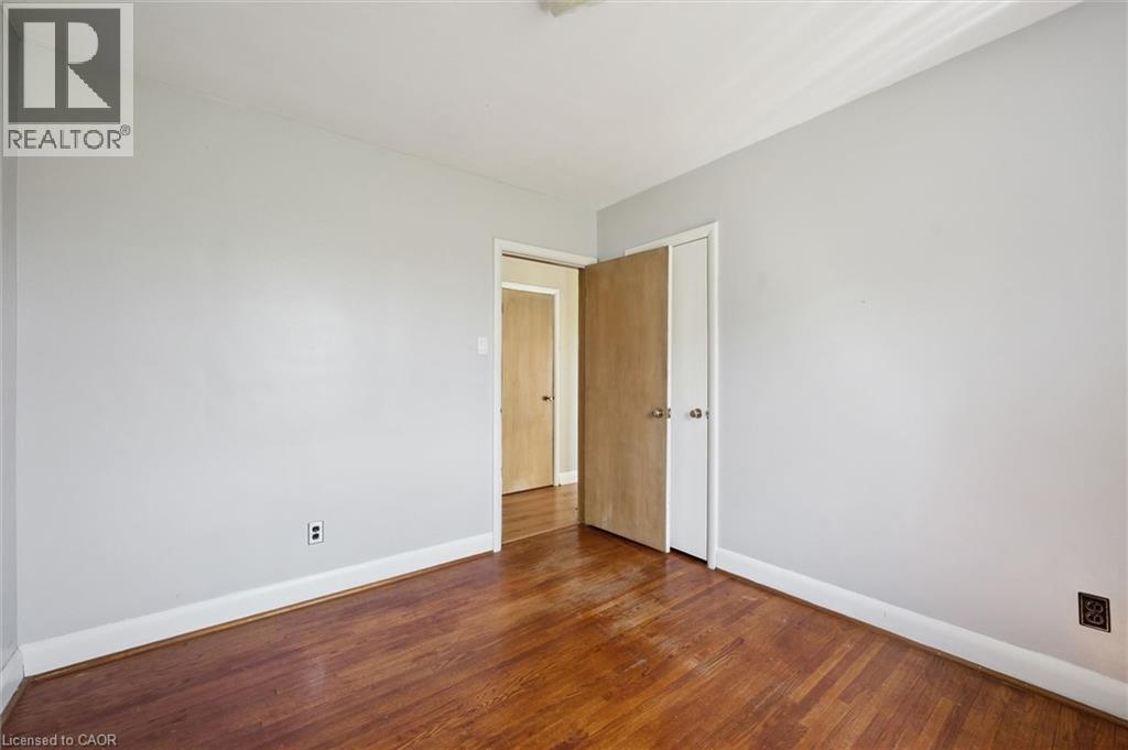 Room featuring wood-finish flooring, light grey walls, and white baseboards