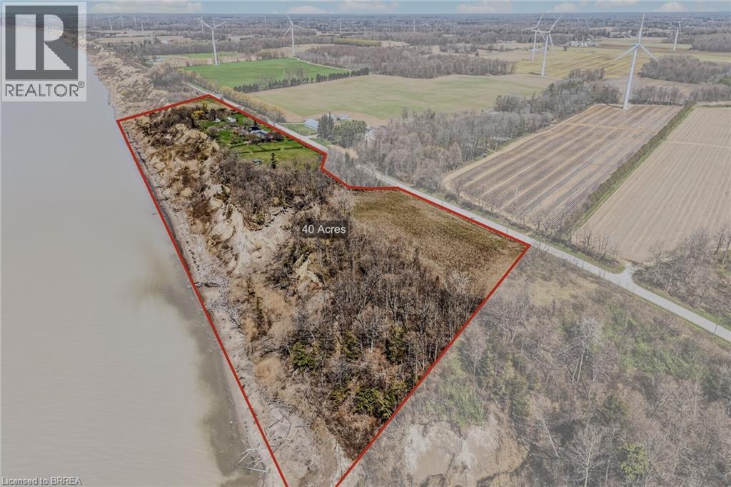Expansive 40-acre parcel featuring waterfrontage, wooded areas, and open fields, bordered by a paved road