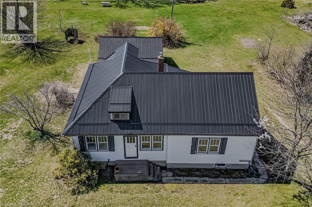 White exterior residence featuring a dark metal roof