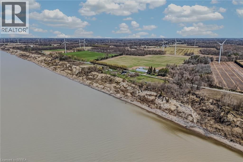 Expansive waterfront property featuring a natural coastline with a sandy beach and mature trees