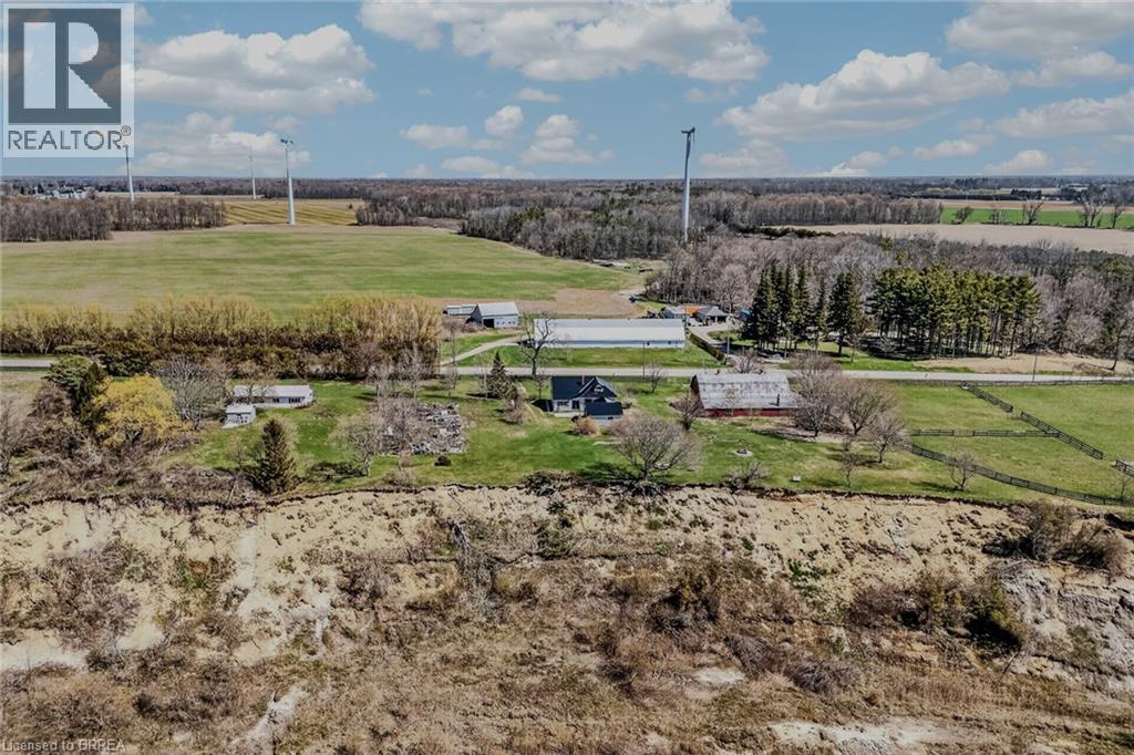 Rural setting featuring expansive fields, mature trees, and multiple outbuildings