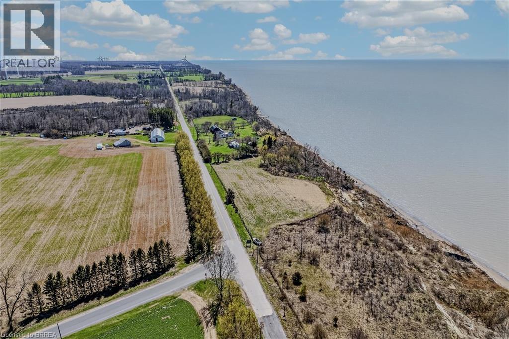 Expansive waterfront property featuring a long stretch of coastline, cultivated fields, and a clearly defined roadway