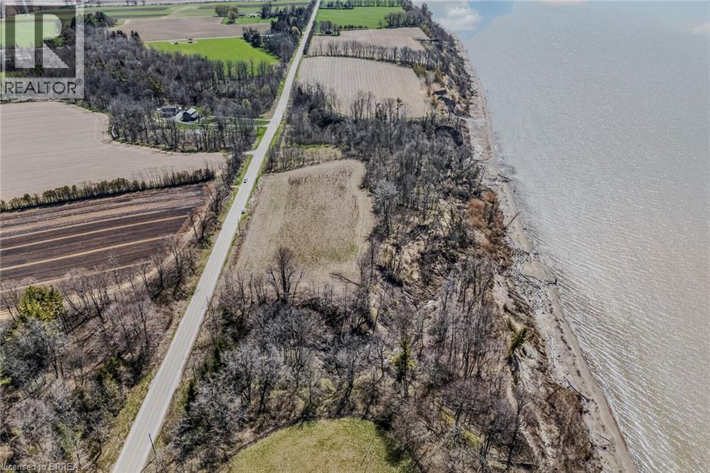 Aerial perspective showcasing a long paved road flanked by cultivated fields and natural tree lines