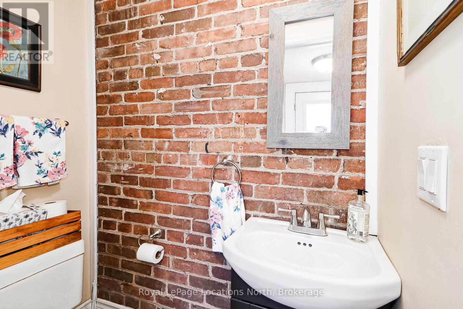 2 pc bathroom with exposed brick wall