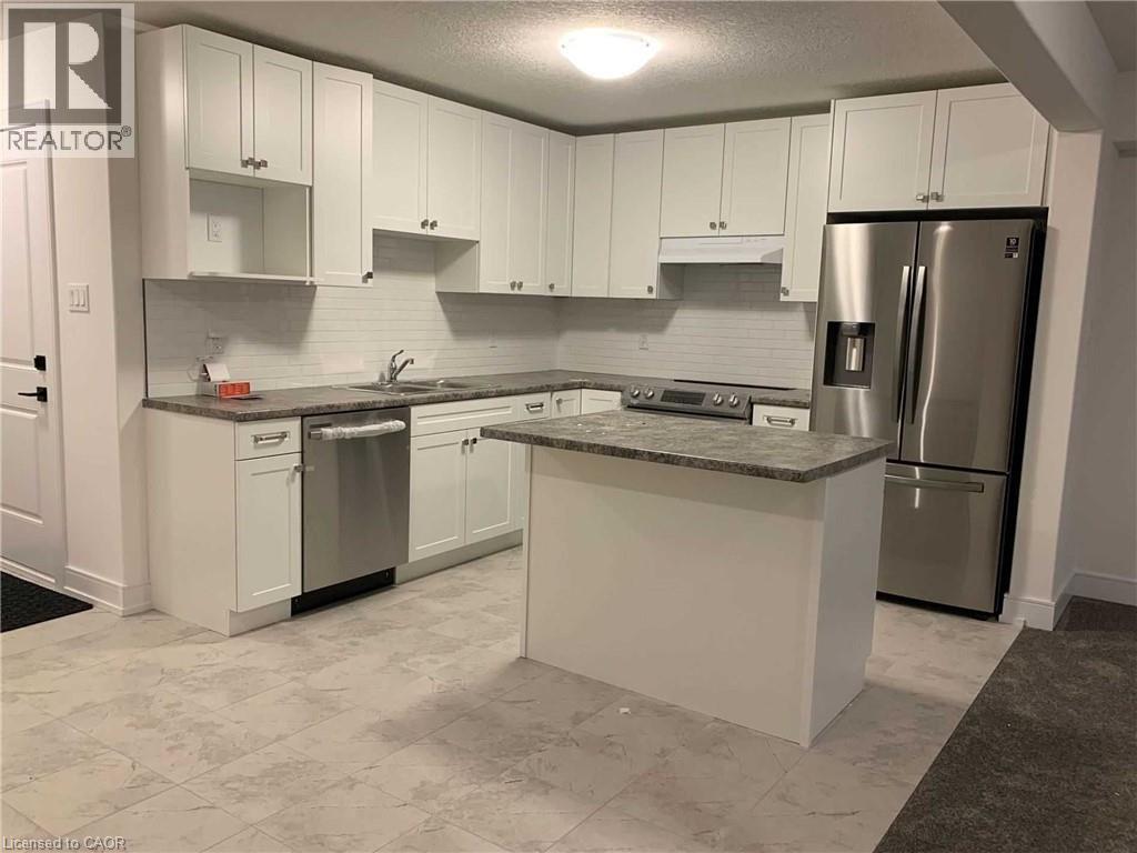 Modern kitchen featuring white shaker cabinetry, stainless steel appliances, a center island with countertop, subway tile backsplash, and light-toned tile flooring