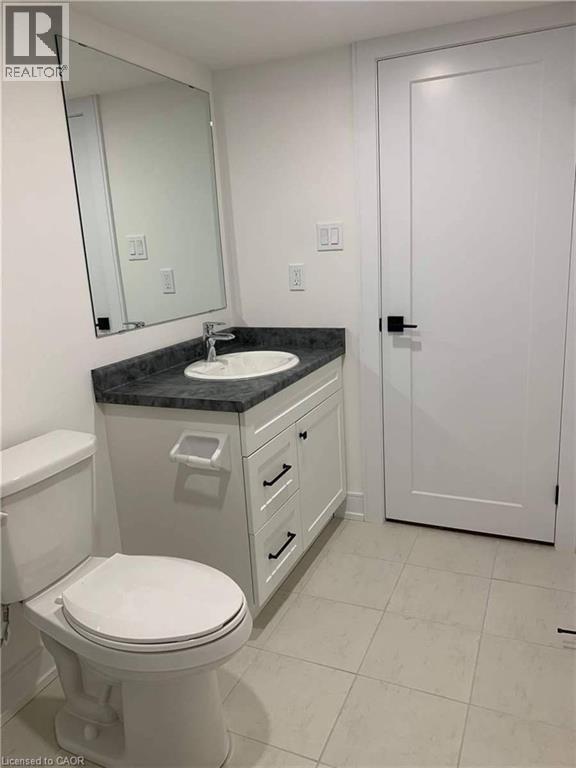 Bathroom featuring a white vanity with dark countertop, undermount sink, and chrome faucet
