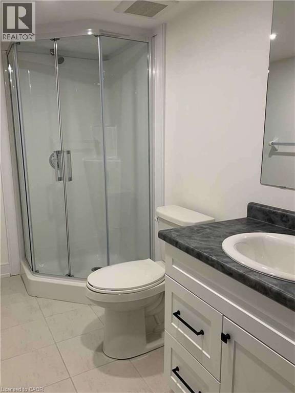Corner shower enclosure featuring clear glass panels and a chrome-finish shower head