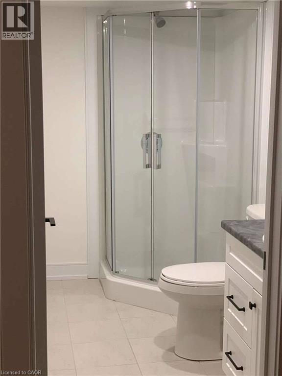 Corner shower enclosure featuring clear glass panels and a chrome shower head