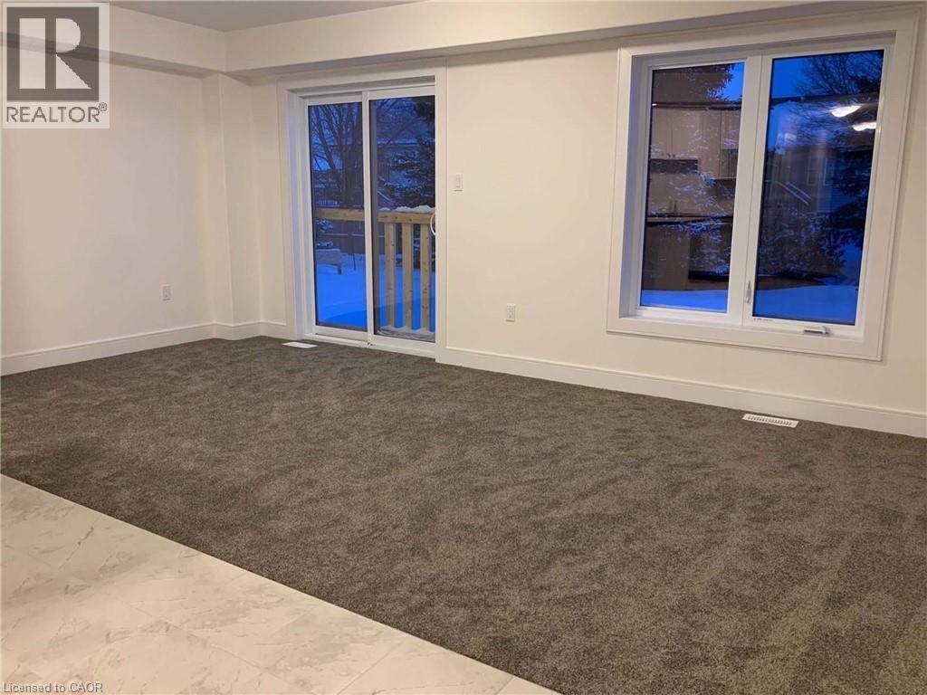 Spacious room featuring new gray carpeting and light-toned wall finishes