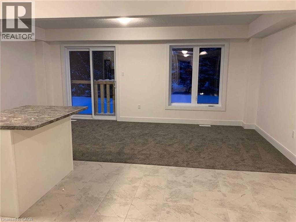 Spacious room featuring a sliding glass door, an expansive window, light-toned walls, and a multi-textured flooring design