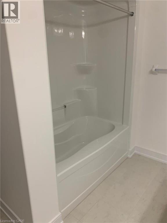 Integrated tub-shower unit featuring a white acrylic finish, built-in shelving, and a chrome shower rod
