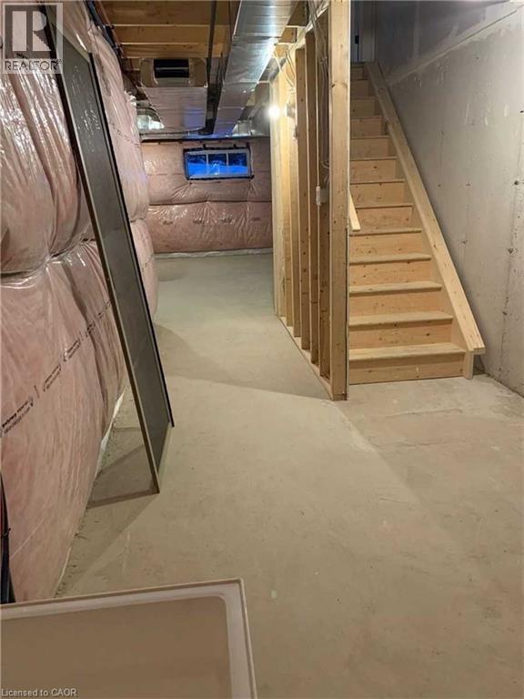 Unfinished basement offering development potential with exposed framing, concrete flooring, and visible insulation