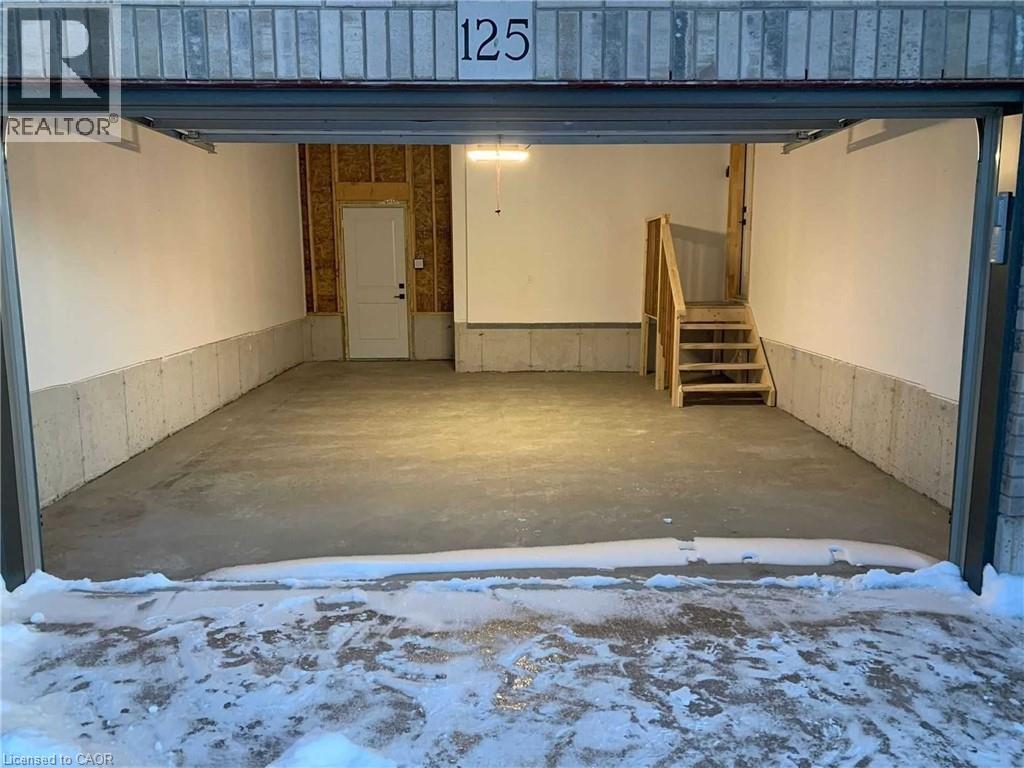 Spacious garage featuring a concrete floor, painted white walls, and an interior access door