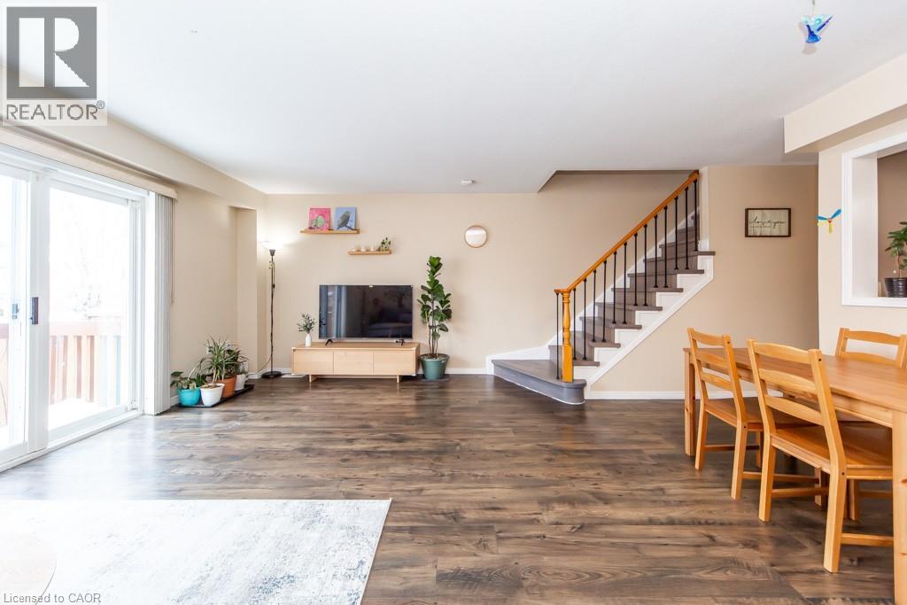 Living room with stairs and dark wood-style flooring