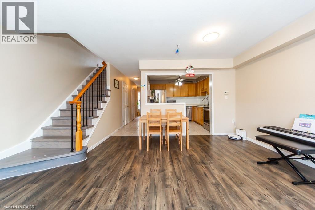 Dining area with dark wood-style floors, a ceiling fan, and a baseboard heating unit