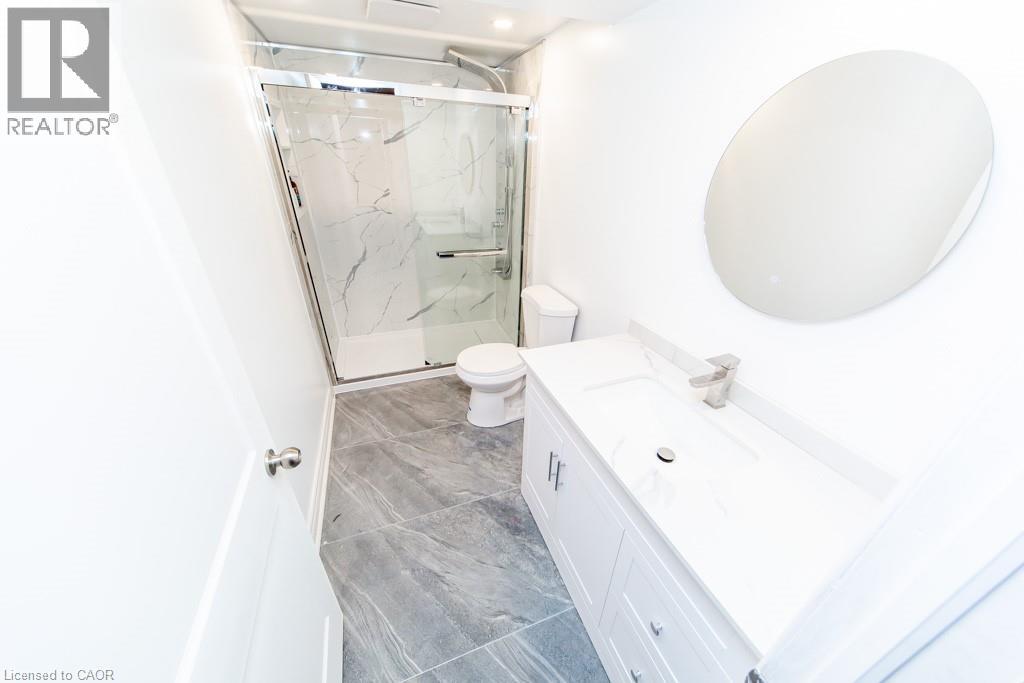 Bathroom featuring vanity and a marble finish shower