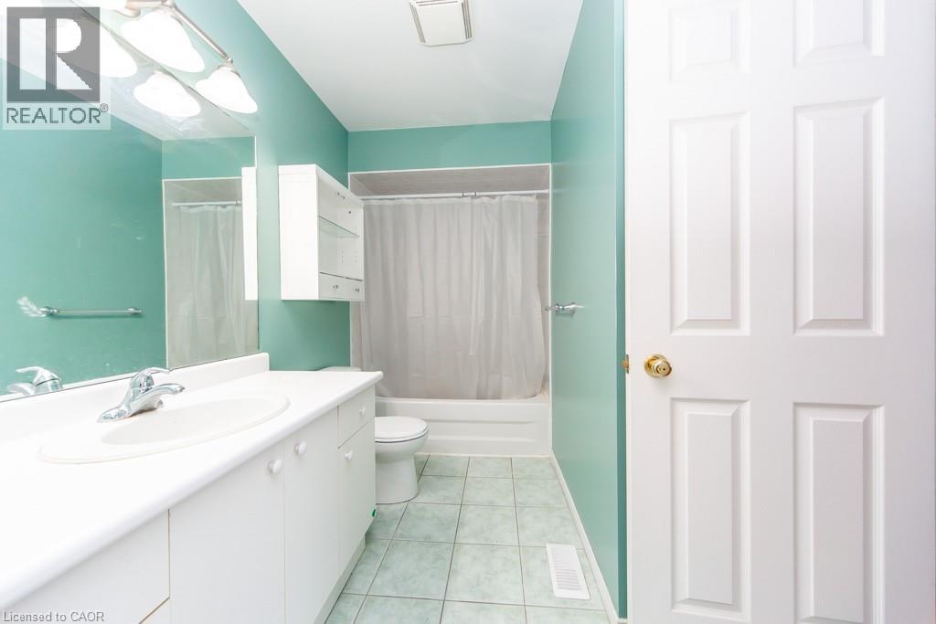 Full bathroom with vanity, shower / bathtub combination with curtain, and light tile patterned flooring