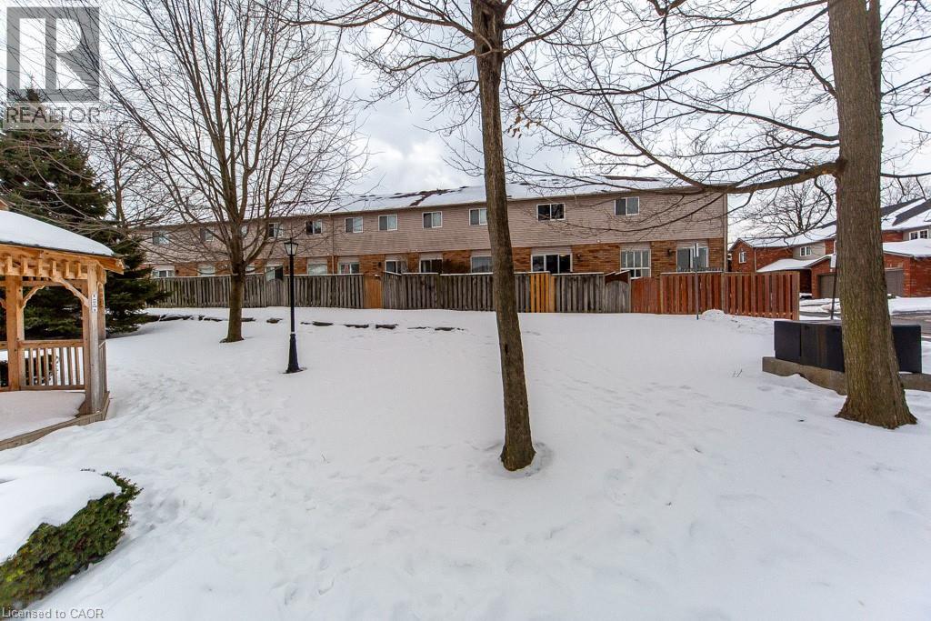 Yard covered in snow with a gazebo and a residential view