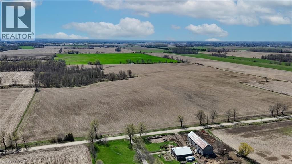 Expansive agricultural landscape featuring large cultivated fields and scattered wooded areas