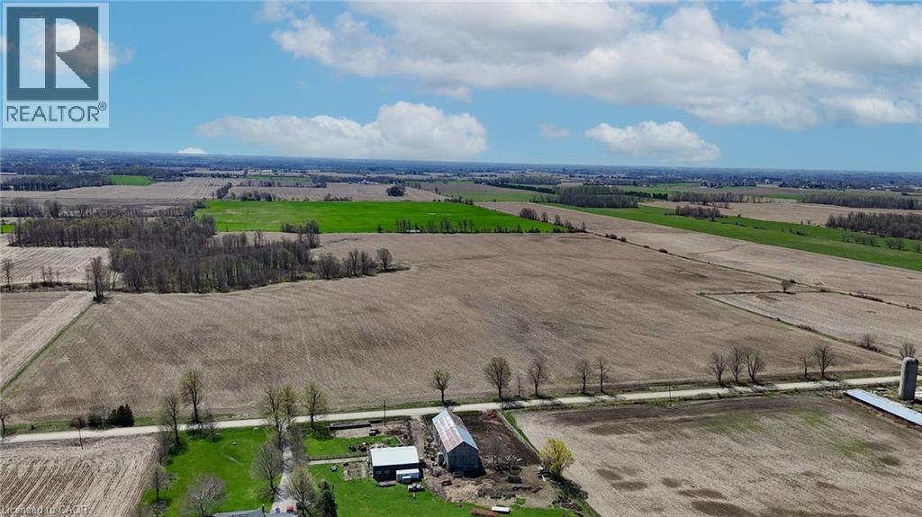 Expansive agricultural property featuring cultivated fields, mature tree lines, and a barn structure