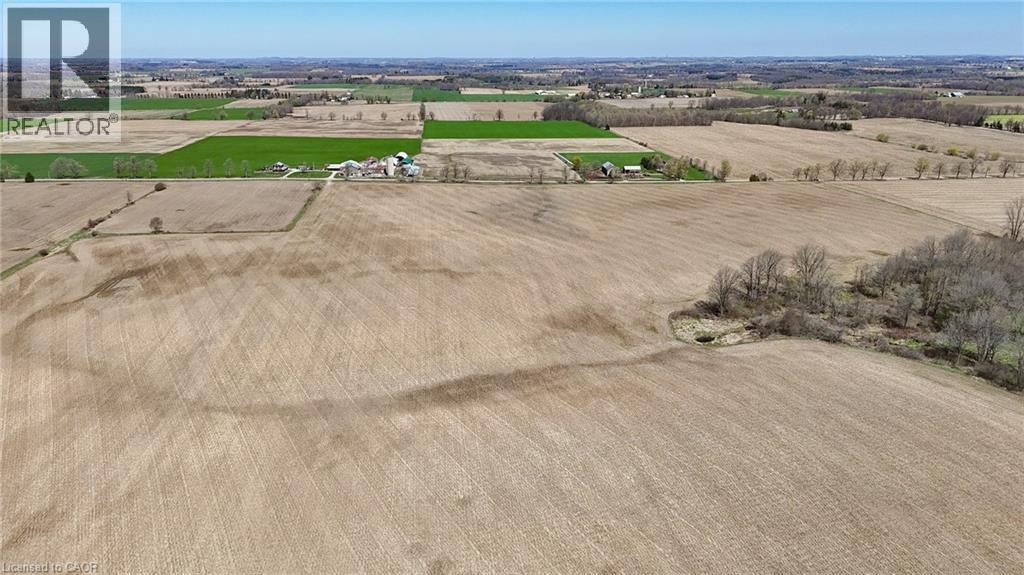 Expansive agricultural land featuring cultivated fields and scattered tree lines