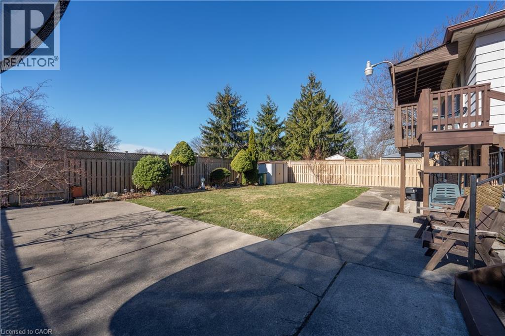 Fenced backyard featuring a patio area and a storage unit