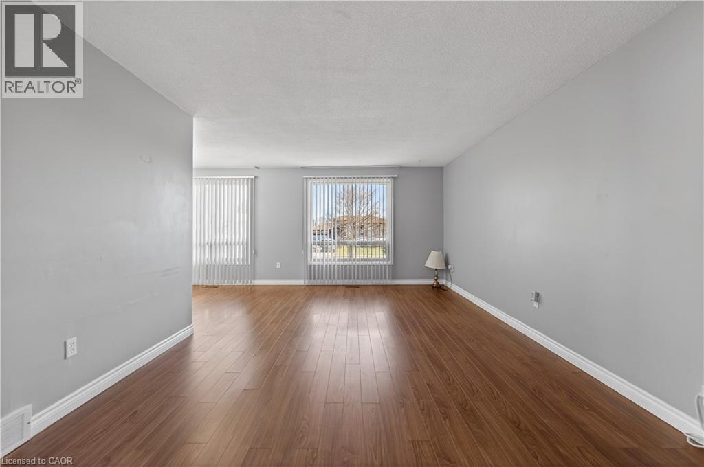 Empty room with dark wood finished floors, a textured ceiling, and radiator