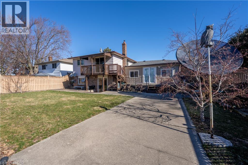 Back of house featuring a chimney, a deck, and a patio