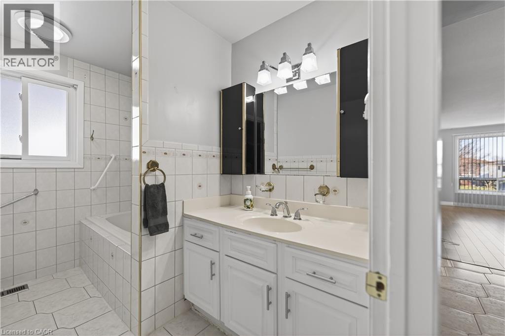 Bathroom featuring vanity, light tile patterned floors, and tile walls