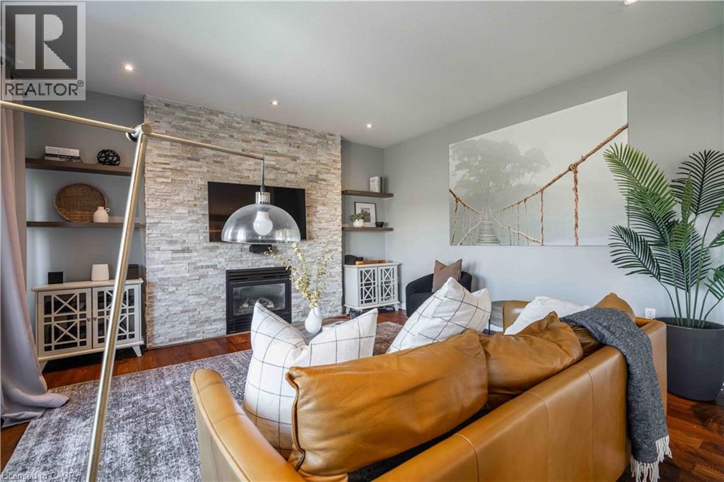 Family Room featuring Engineered hardwood finished floors, a stone fireplace, and recessed lighting