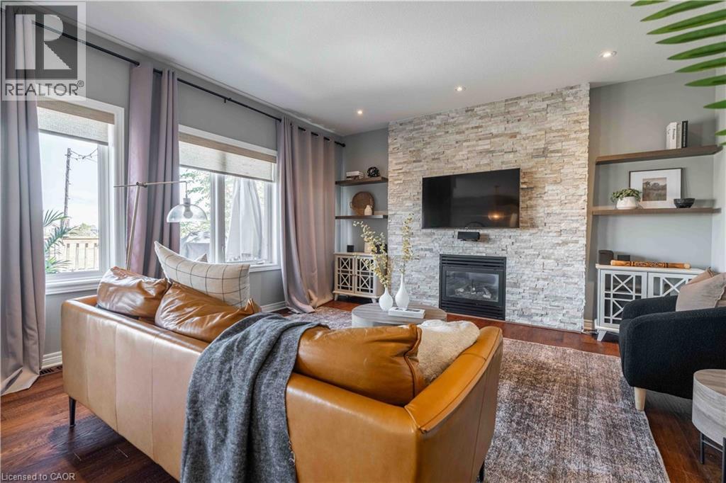 Living area with wood finished floors, a fireplace, built in features, and recessed lighting