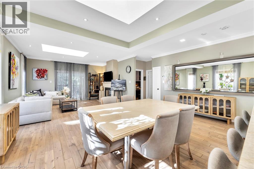 Open-concept living space featuring wood-finish flooring, recessed lighting, and a skylight