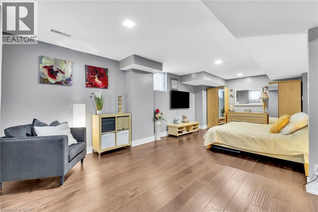 Spacious open-concept room featuring wood-finish flooring, recessed lighting, and light grey wall tones