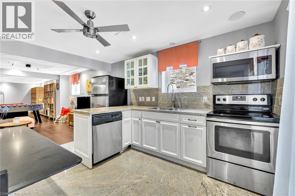 Kitchenette featuring white cabinetry, granite-finish countertops, and stainless steel appliances