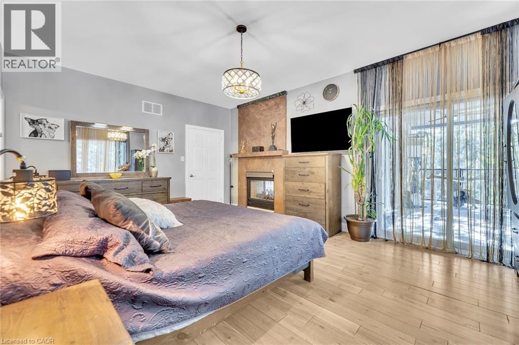 Room featuring light wood-finish flooring, a contemporary fireplace with a stone surround, and a coordinating wood mantel