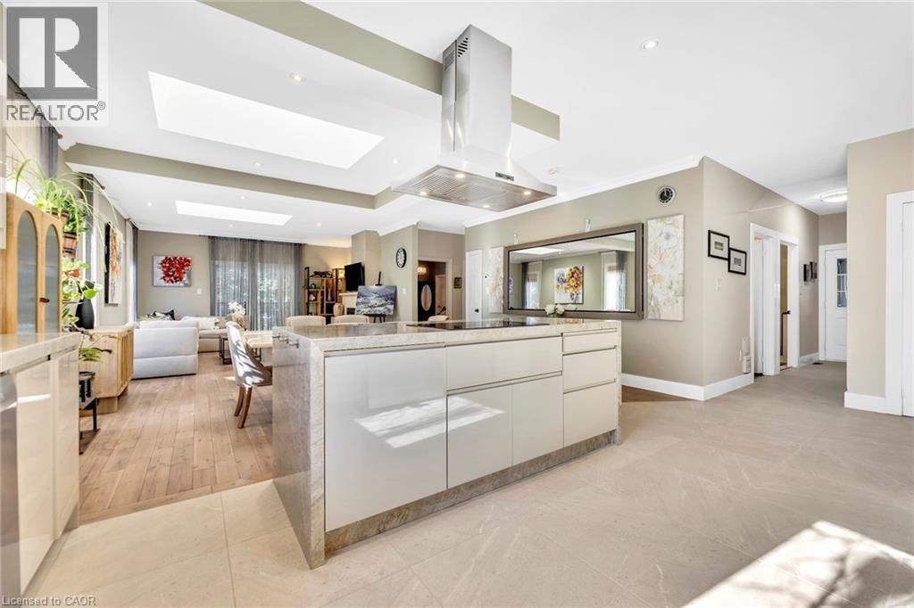 Gourmet kitchen with a large central island, integrated cooktop, and contemporary range hood