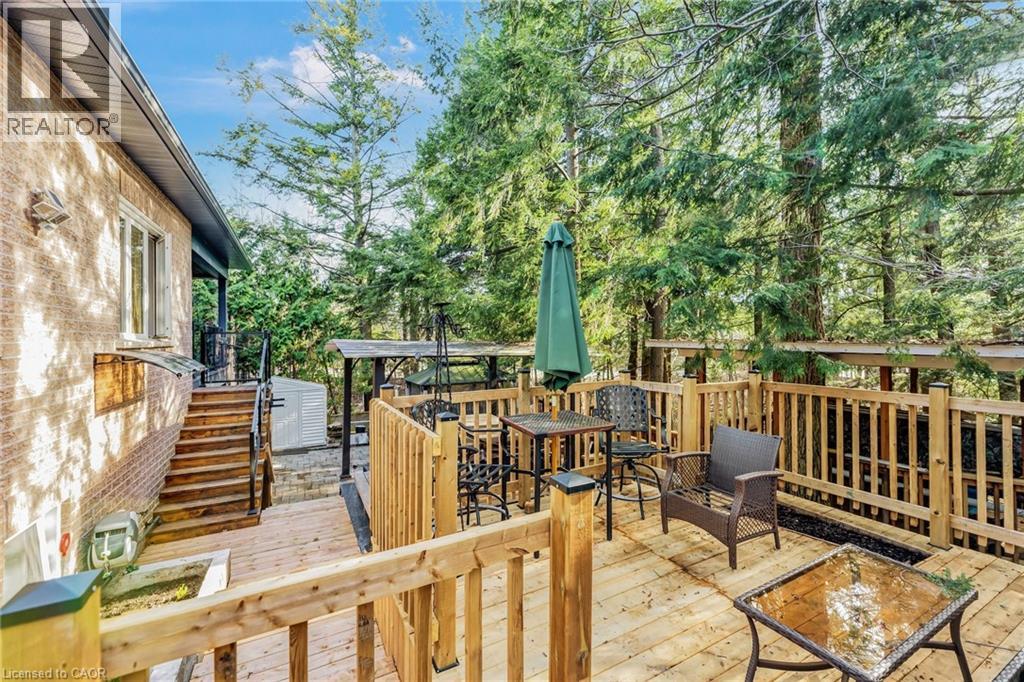 Expansive wood-plank deck featuring a wood railing and mature trees