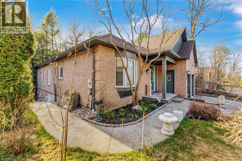 Brick exterior featuring a covered porch entry, bay window, integrated garage, and a concrete pathway