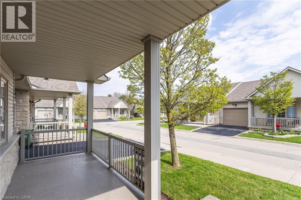 Covered front porch featuring a textured concrete floor and decorative metal railings