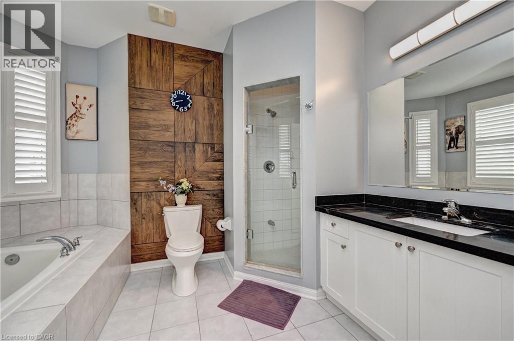 Full bathroom featuring a single vanity with dark countertop, built-in tub, enclosed shower, and wood-panel accent wall