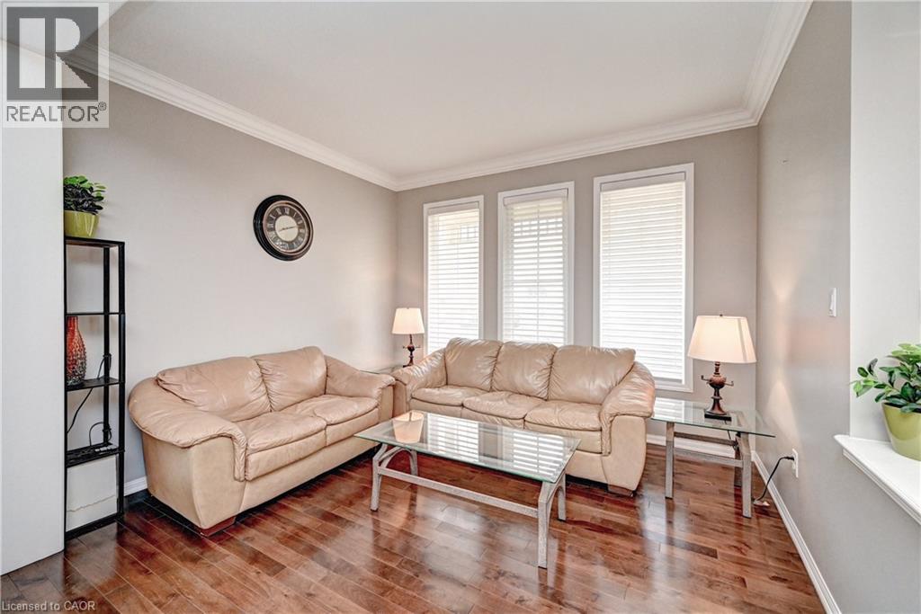 Living area featuring wood-finish flooring, light grey walls, and white crown molding