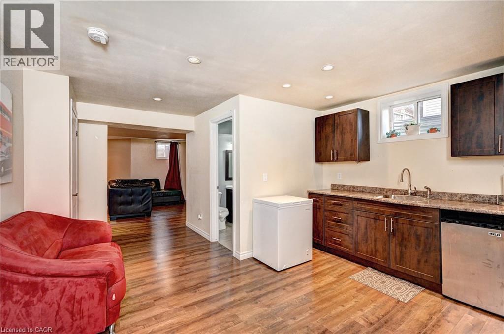 Lower-level recreation space featuring wood-finish flooring, recessed lighting, and a kitchenette