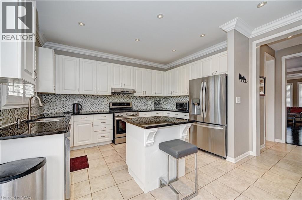 Kitchen featuring extensive white cabinetry, dark countertops, tile backsplash, stainless steel appliances, and recessed lighting