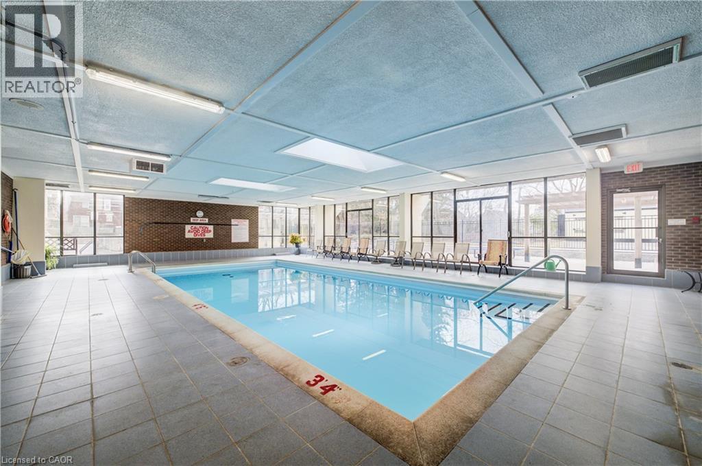 Indoor community pool featuring a sunroom