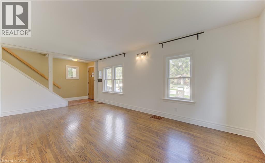 Spacious room featuring wood-finish flooring, white baseboards, and multiple windows