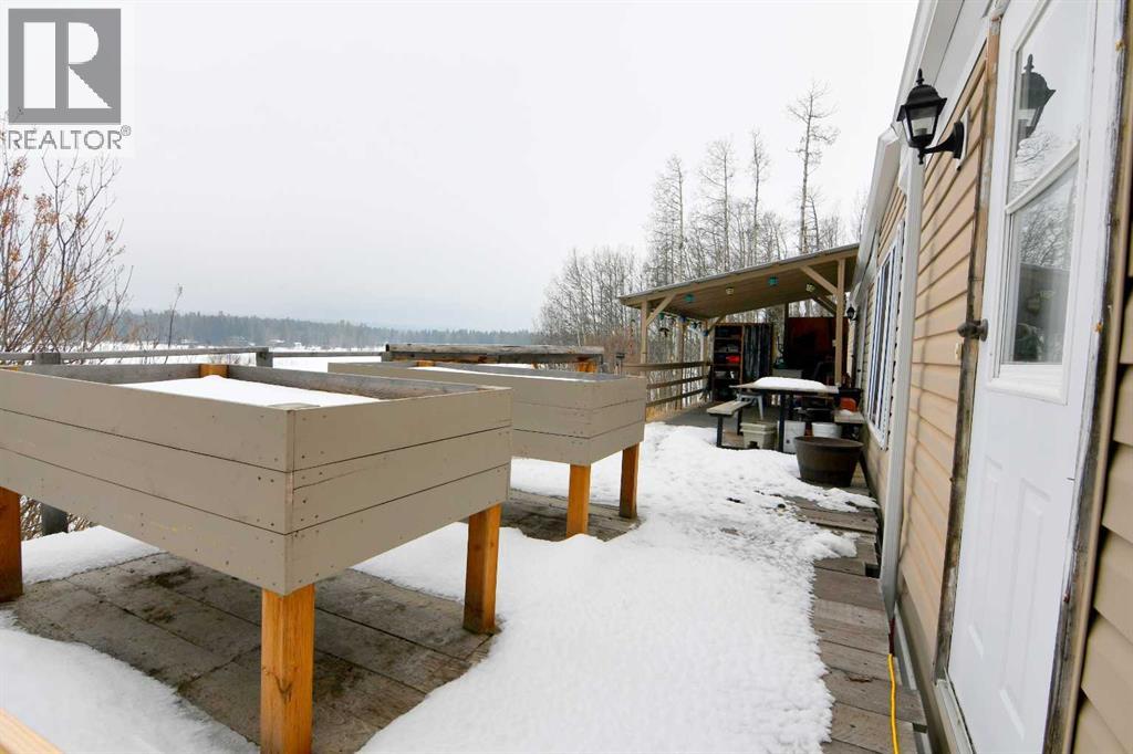 South side of house with raised garden beds and partial covered deck