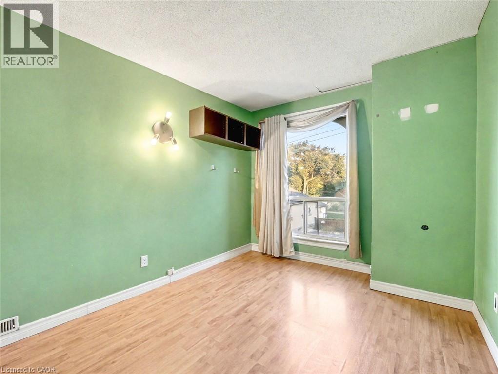 Spare room with light wood-type flooring and a textured ceiling