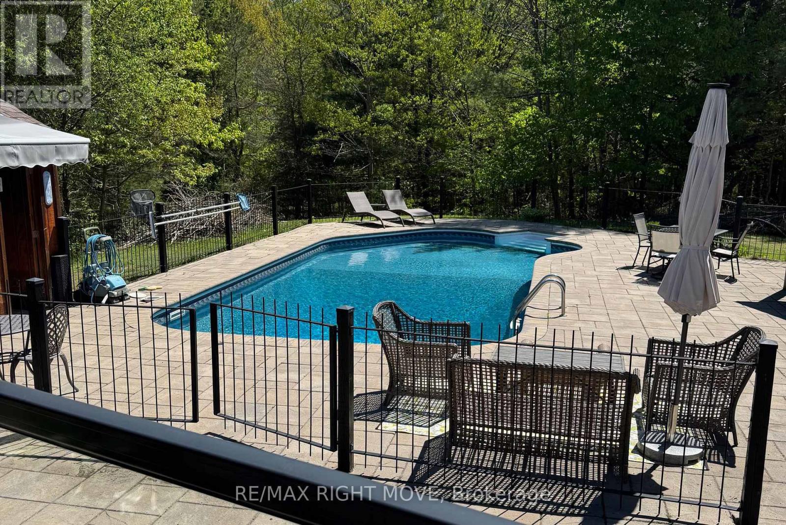 In ground pool w/ unistone decking & iron fence