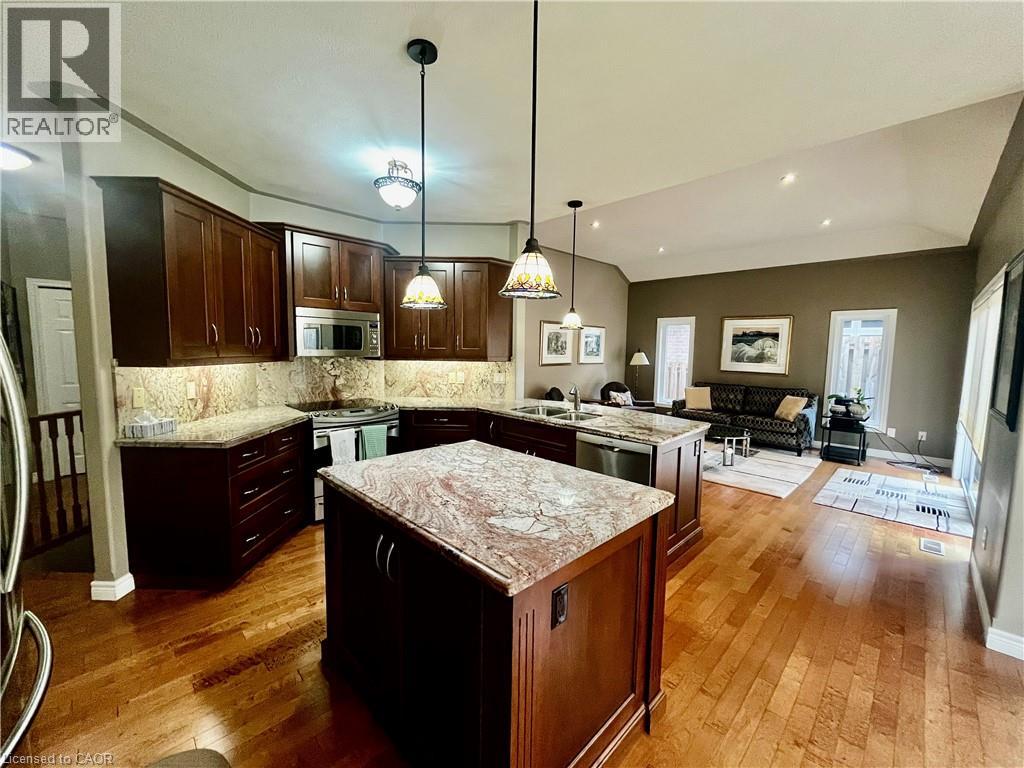 This expansive kitchen features dark wood cabinetry, granite countertops, and stainless steel appliances