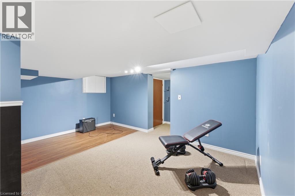 Finished room featuring a recessed white ceiling panel, track lighting, and a combination of wood-finish flooring and carpet